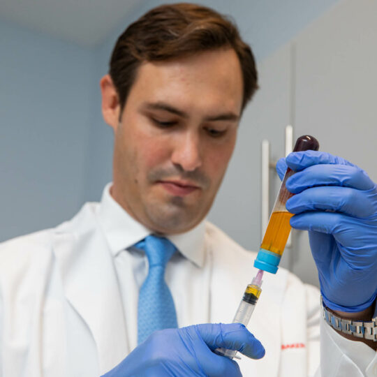 A doctor doing tests with a yellow substance in a tube